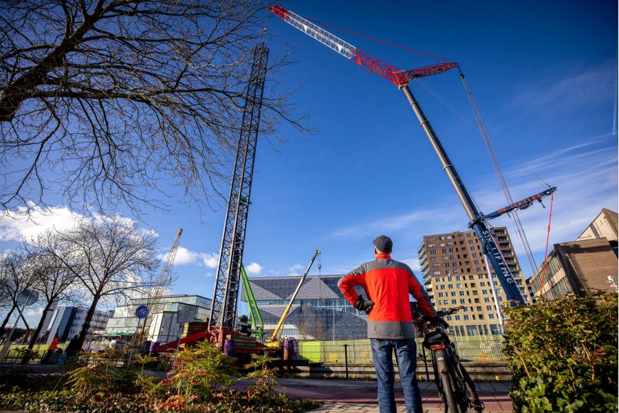 Afbeelding van kraanmachinist Thijs Baas in de bestuurderscabine van zijn torenkraan bij Point of View