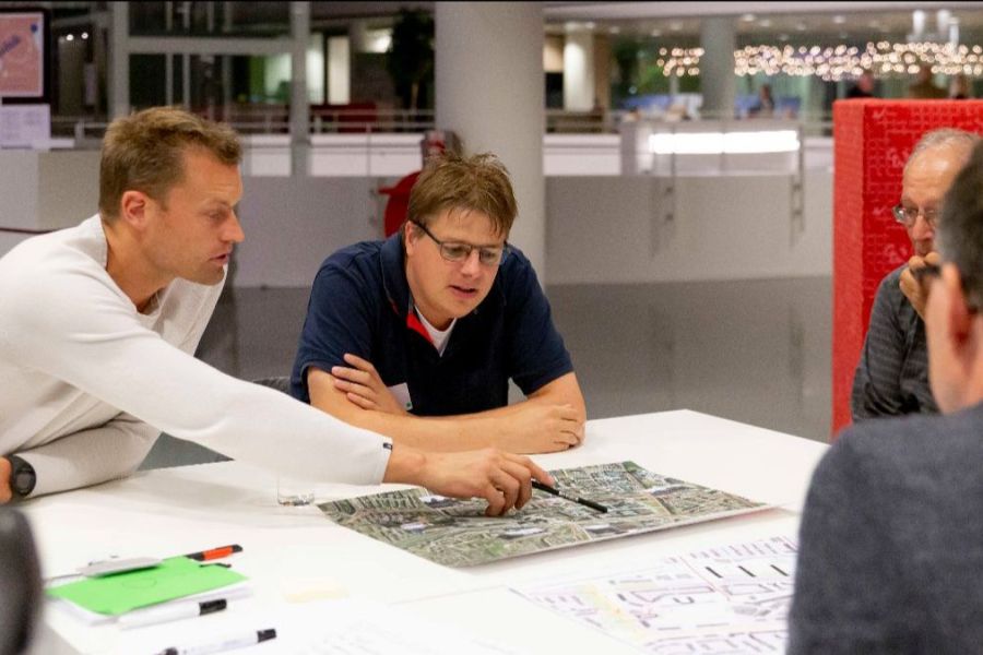 Mensen overleggen aan tafel over bouwplannen